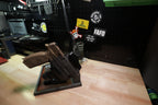 Side view of a gray tactical EDC tray displaying a holstered pistol, with a phone and green watch behind it.