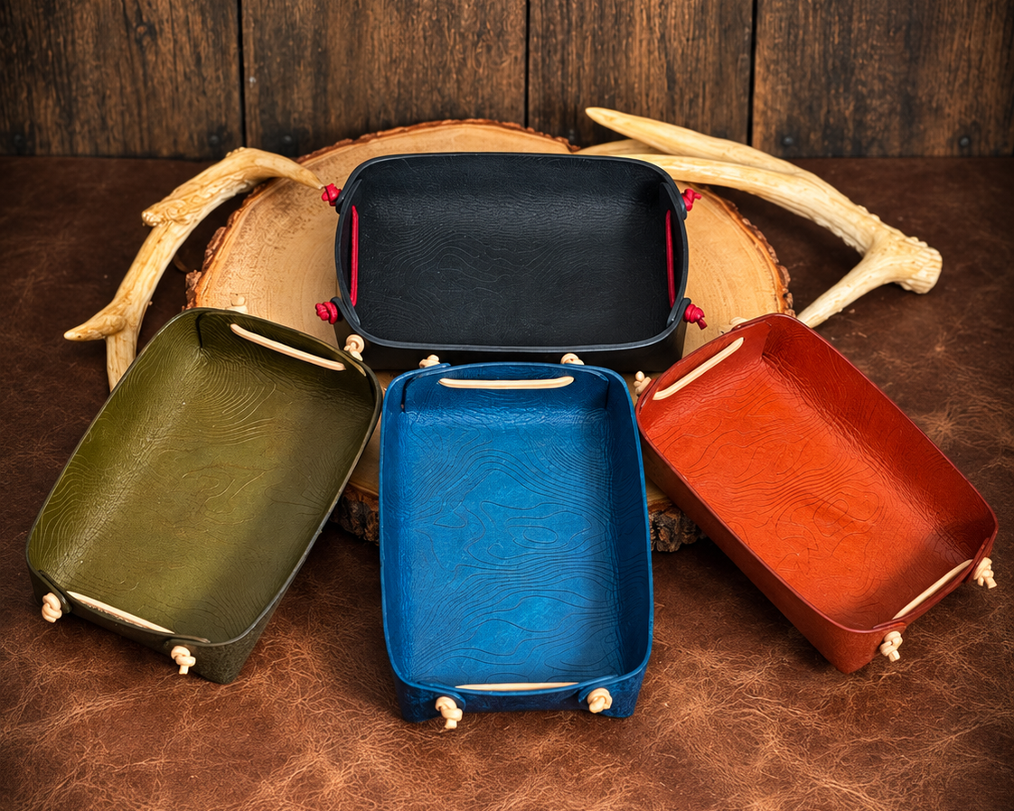 Basecamp leather valet tray color options displayed together on rustic wood