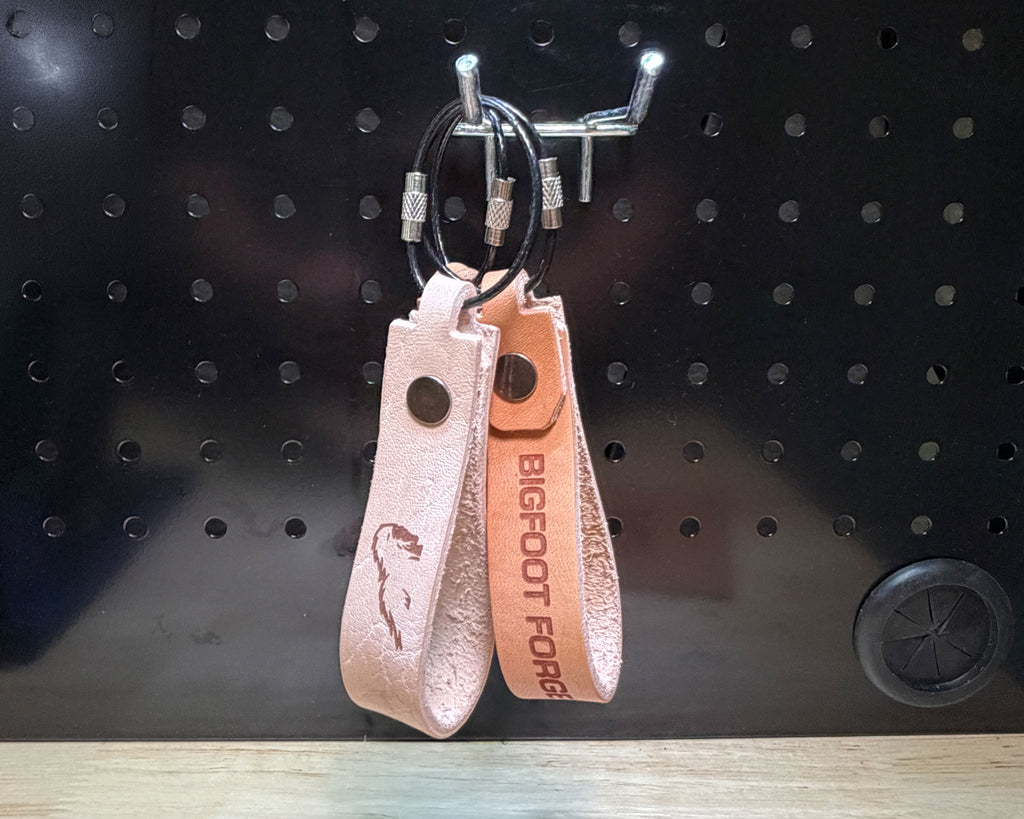 Leather keychains in veg tan  with engraved designs and coated steel cable rings