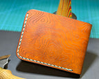 Angled view of a Bourbon Topo leather bifold with baby blue stitching
