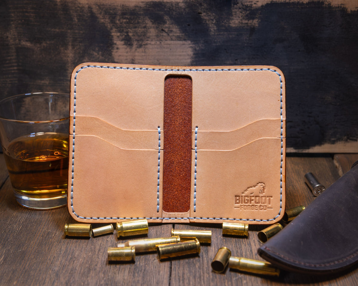 Open Bourbon vertical bifold showing natural leather card pockets, brown center strip and Bigfoot Forge maker's mark.