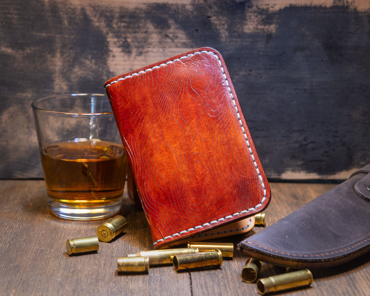 Forgehand Field Bourbon vertical leather wallet with a hand-dyed amber and reddish-brown gradient and contrast stitching.