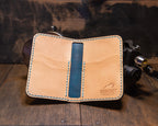 Open Deep Blue Water vertical bifold showing natural leather card pockets, blue center strip and Bigfoot Forge maker's mark.