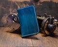 Forgehand Field Deep Blue Water vertical leather wallet with hand-dyed blue gradient, topo engraving and light contrast stitching.