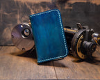 Forgehand Field Deep Blue Water vertical leather wallet with hand-dyed blue gradient, topo engraving and light contrast stitching.