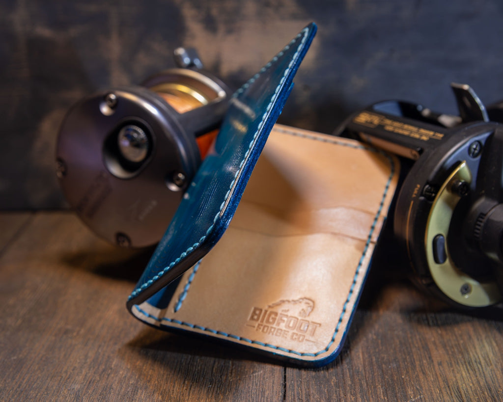 Side view of the Deep Blue Water vertical wallet showing its fold, leather edges and interior maker's mark.