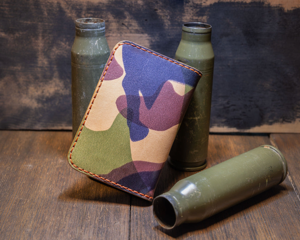 Angled view of the Woodland Camo vertical wallet showing the camouflage leather pattern and stitched perimeter.